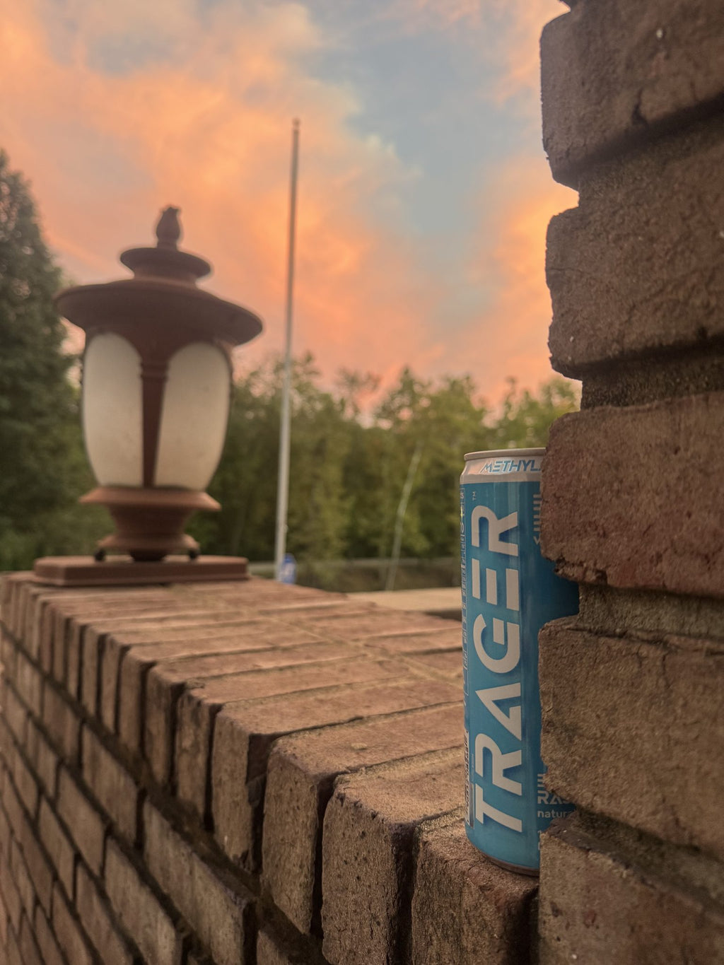 Trager Blue Raspberry can on a brick wall at sunset